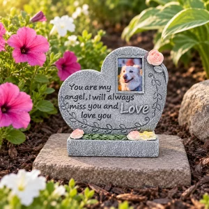 Angel Heart pet memorial plaque, on a flat garden paver beside flowers, garden setting