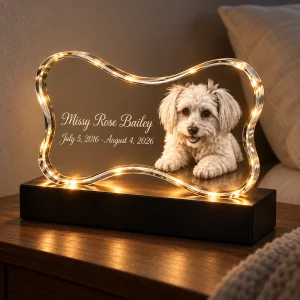 Warmly lit bone-shaped pet memorial crystal lamp on an indoor bedside table