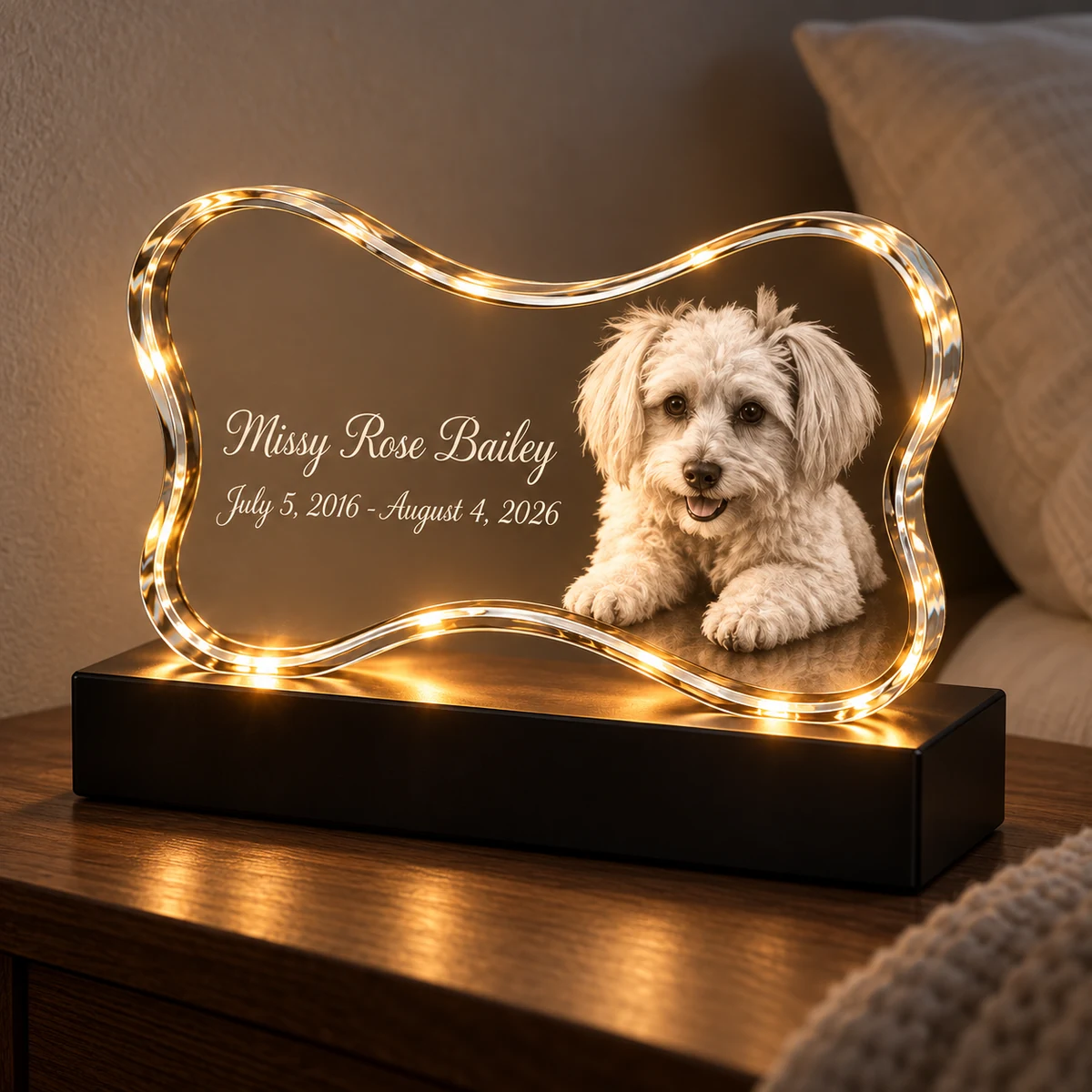 Warmly lit bone-shaped pet memorial crystal lamp on an indoor bedside table