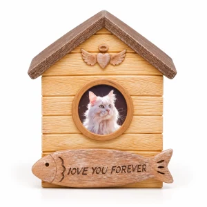 Front view of house-shaped cat urn with circular photo frame and fish plaque