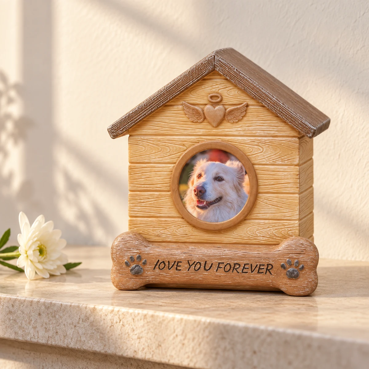 Dog house memorial urn beside a white flower on a sunlit stone shelf