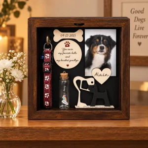 Dog memorial shadow box displayed on an indoor remembrance shelf beside flowers