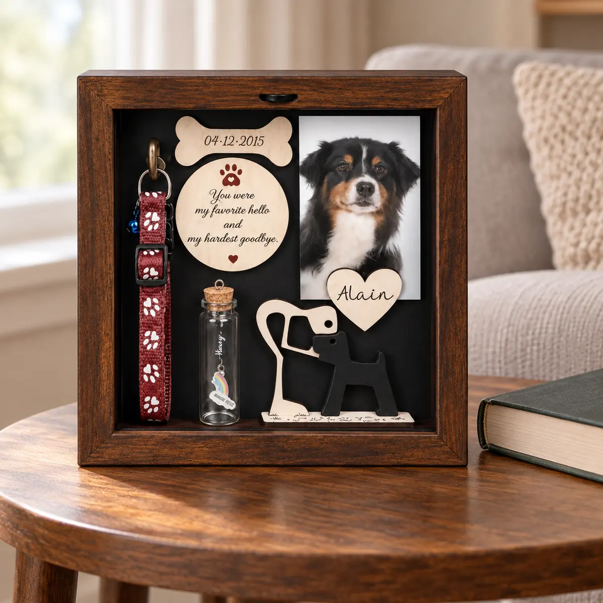 Dog memorial shadow box on an indoor side table beside a book