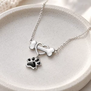 Sterling Silver Dog Bone Necklace with Heart and Paw, on a jewelry tray